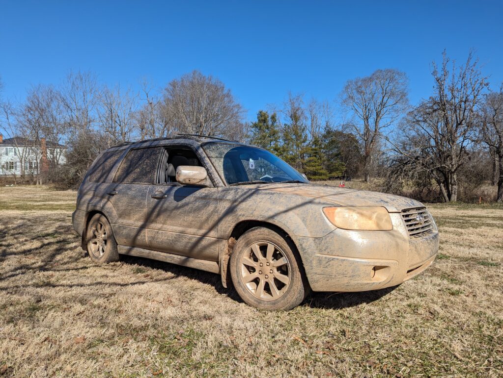 subaru forester sg covered in dirty and mud from racing in dirt