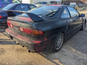 red integra with crappy black spray paint over it