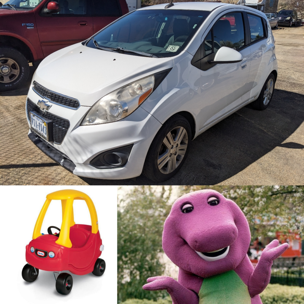 white chevrolet spark with a cozy coupe and barney the dinosaur.